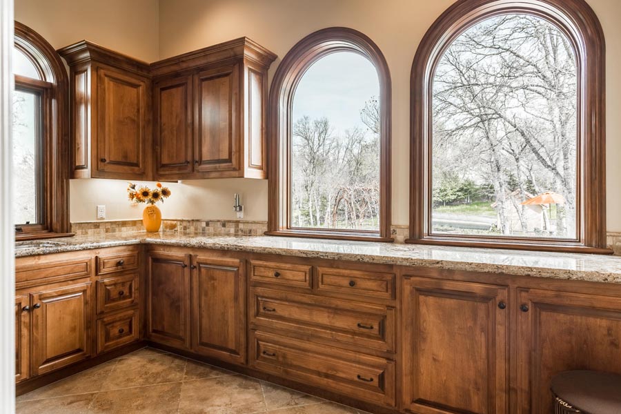 Laundry room with lots of windows and alder wood cabinets. 