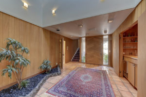 Vintage entry way with wood siding and hidden wetbar in entry way of 3600 Kiekebusch Court